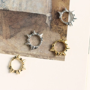 Detailed view of punk style 925 silver rivet hoop earrings in gold and silver finishes