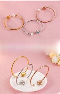 Detailed close-up of open pearl bracelets in gold, silver and rose gold finishes