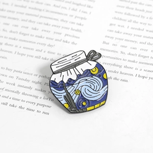 Detail of Van Gogh Starry Night enamel brooch pin displayed on an open book page