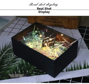 Close-up of 3mm iridescent shredded raffia with warm LED lights in a gift box packaging