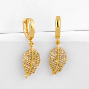 Elegantes pendientes de hoja dorada con cristales de circón en fondo blanco
