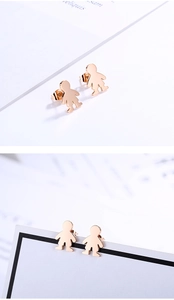 Detailed close-up of rose gold stainless steel boy silhouette stud earrings on a paper