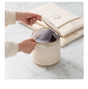 Detailed view of hands opening a reinforced mesh laundry bag for delicate bras and lingerie