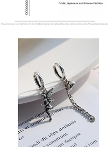 Detailed close-up of vintage silver asymmetric chain earrings with fairy and heart pendants