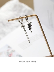 Detailed close-up of asymmetric vintage silver chain earrings with an angel fairy silhouette