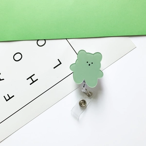 Close-up of green bear retractable badge holder with durable clear strap for nurses