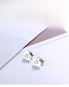 Détail de boucles d'oreilles en cœur avec patte ajourée et petit strass brillant