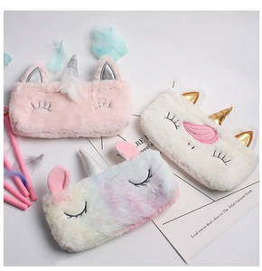 Flat lay of colorful plush unicorn pencil cases with soft texture and metallic horn detail
