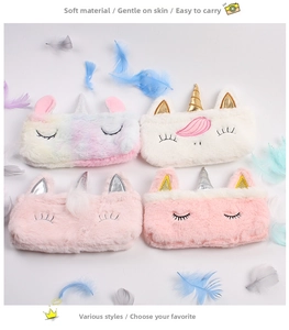 Close-up of four plush unicorn pencil cases in rainbow and pastel colors on white background