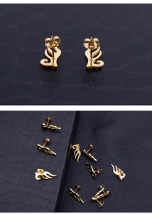 Detailed close-up of golden stainless steel angel wing stud earrings on black texture
