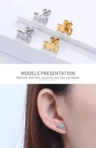 Detail showing 'I Love U' heart stud earrings in gold and silver on a female model