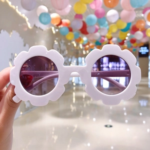 Detail of flower shaped sunglasses for girls with white petals and purple lenses