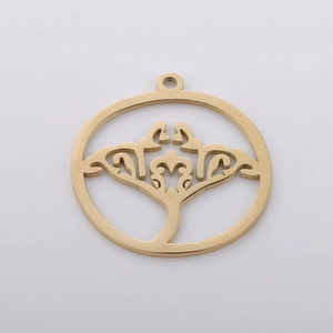 Close-up of golden hollow round metal pendant with intricate tree pattern details