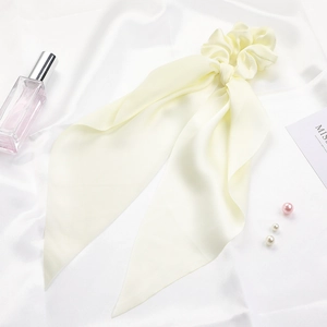 Close-up of light yellow satin ribbon hair scrunchie with soft silk-like texture