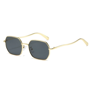 Chic polygonal gold metal sunglasses with wavy temples and dark lenses on white background
