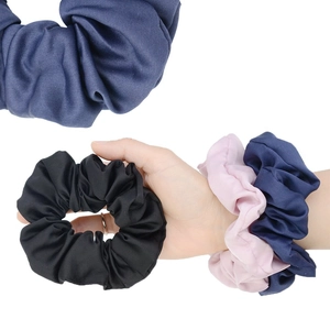 Set of satin scrunchies in black, navy, and pink shown on wrist and as product shot