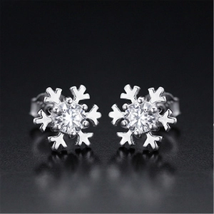 Macro shot of silver snowflake stud earrings featuring central round-cut clear cubic zirconia