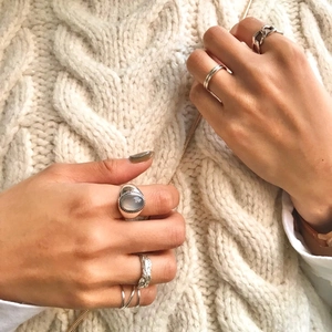925 silver agate ring set with textured metal bands on white knit sweater
