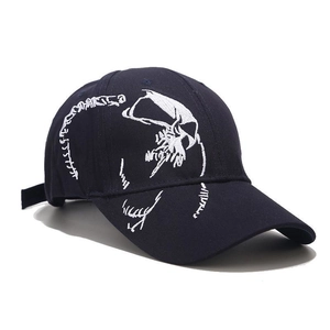 Close-up of intricate white skull embroidery on navy cotton canvas baseball cap fabric