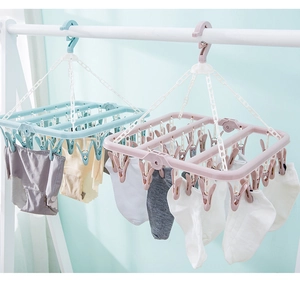 Detail of blue and pink multi-clip drying racks hanging socks on a sturdy white stand