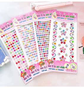 Detailed view of four colorful 3D heart and star DIY crystal stickers on pink background