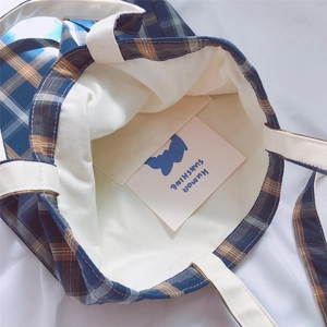Detail view of the plaid cotton tote bag interior showing the inner pocket and large capacity