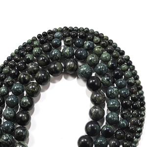 Macro detail of natural green tiger eye loose beads showing various sizes and textures
