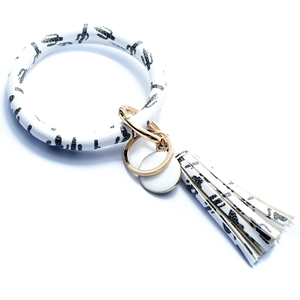 Detail view of white cactus leopard print bangle keychain with fringe tassel and gold rings