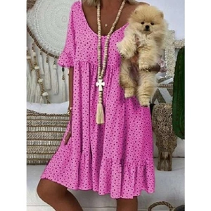 Detalle de vestido rosa de lunares con cuello en V, mangas con volantes y falda a capas