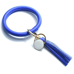 Detail of blue leather O-ring keychain with golden clasp and long stylish tassel