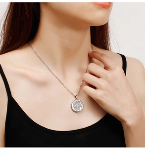 Détail du pendentif main de Hamsa sur un collier rond en acier inoxydable porté par le mannequin