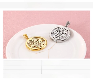 Détail de pendentifs ronds main de Hamsa en or et acier argenté avec incrustation