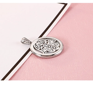 Détail du pendentif main de Hamsa en argent sur cuir rose avec finition acier inoxydable