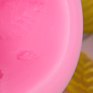 Close-up of pink silicone leaf mold showing detailed textures for fondant cake baking