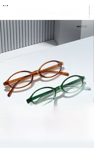 Close-up of stylish amber and emerald green oval spectacle frames on a minimalist white stand