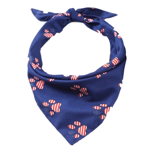 Detail of navy blue pet bandana featuring patriotic dog paw prints with stars and stripes