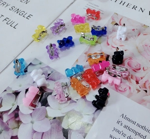 Detail shot of colorful translucent gummy bear brooches with secure metal pin backings