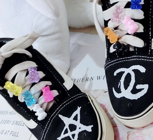 Detail of colorful resin gummy bear charms decorating black canvas sneakers