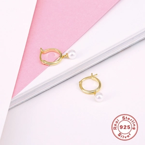 Detailed close-up of a gold S925 sterling silver hoop earring with a white freshwater pearl