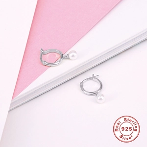 Macro detail of S925 sterling silver hoop earrings with white freshwater pearls