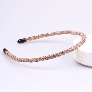 Detail of slim metal headband fully inlaid with champagne rhinestones and black end tips
