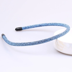 Detail of royal blue rhinestone headband on white bowl showing sparkle and comfort tips