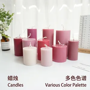 Cylindrical DIY scented candle mold and wax pillars in assorted pink and burgundy colors