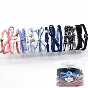 Detailed set of 12 elastic hair ties with pearls and bows in a clear storage jar