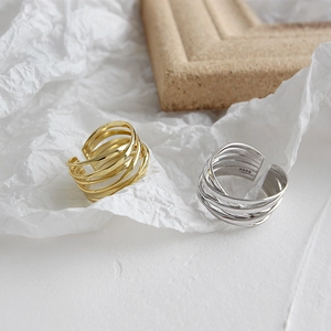 Close-up of S925 silver and gold multilayer irregular rings on artistic paper background