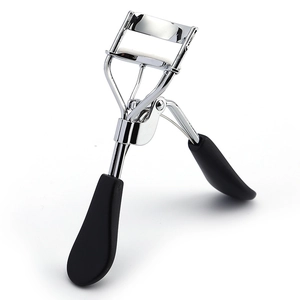 Close-up of eyelash curler with silver stainless steel body and black rubber handle