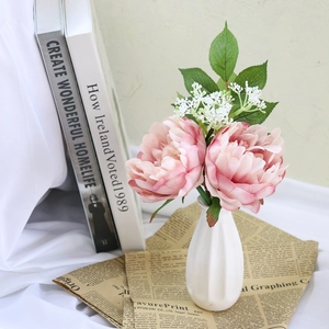 Pink artificial peony flower bouquet in white ceramic vase for home interior decoration