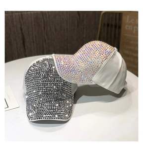 Dettaglio di cappellini da baseball bianchi con decorazioni di strass scintillanti