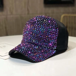 Dettaglio macro di strass viola e blu su un berretto da baseball nero alla moda