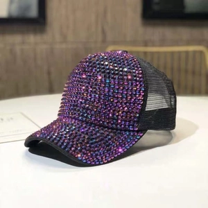 Dettaglio di strass colorati su un cappellino trucker in rete nera con tessuto traspirante